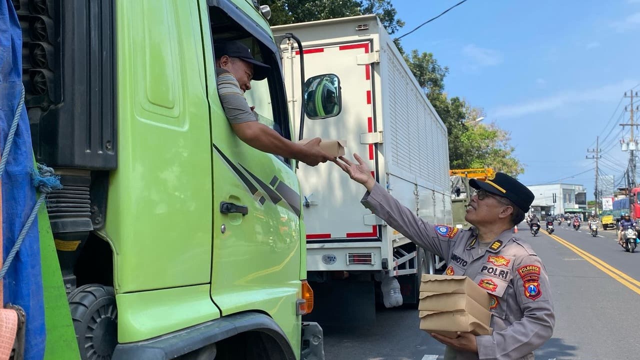Polresta Banyuwangi Bagi-Bagi nasi kotak untuk Sopir Truk logistik yang Mengalami Antrian